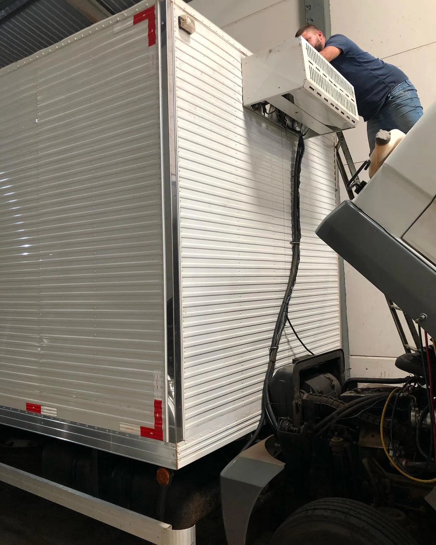 Técnico instalando unidade de refrigeração em baú frigorífico de caminhão