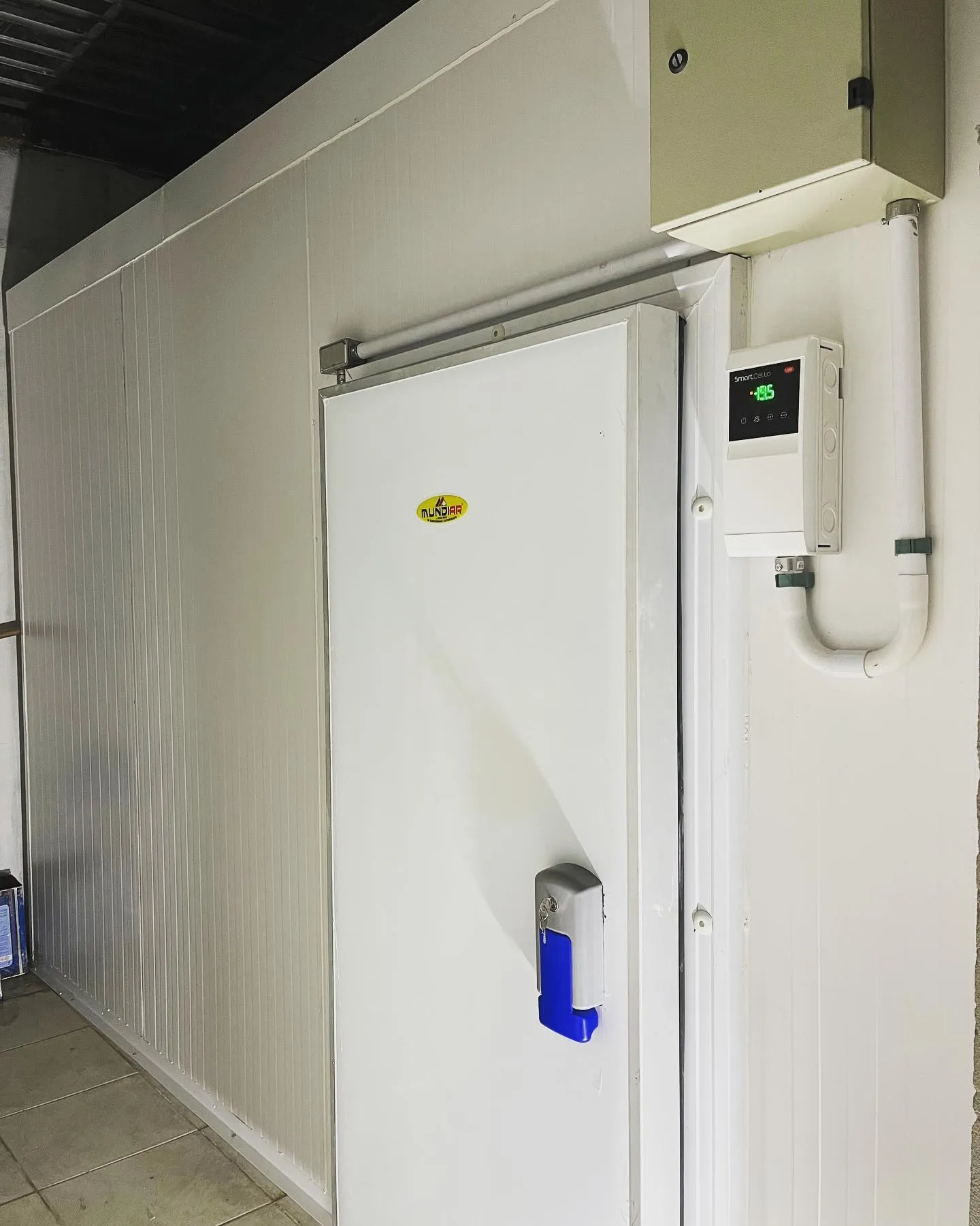 Porta de câmara de congelados com controlador digital marcando -19,5 °C
