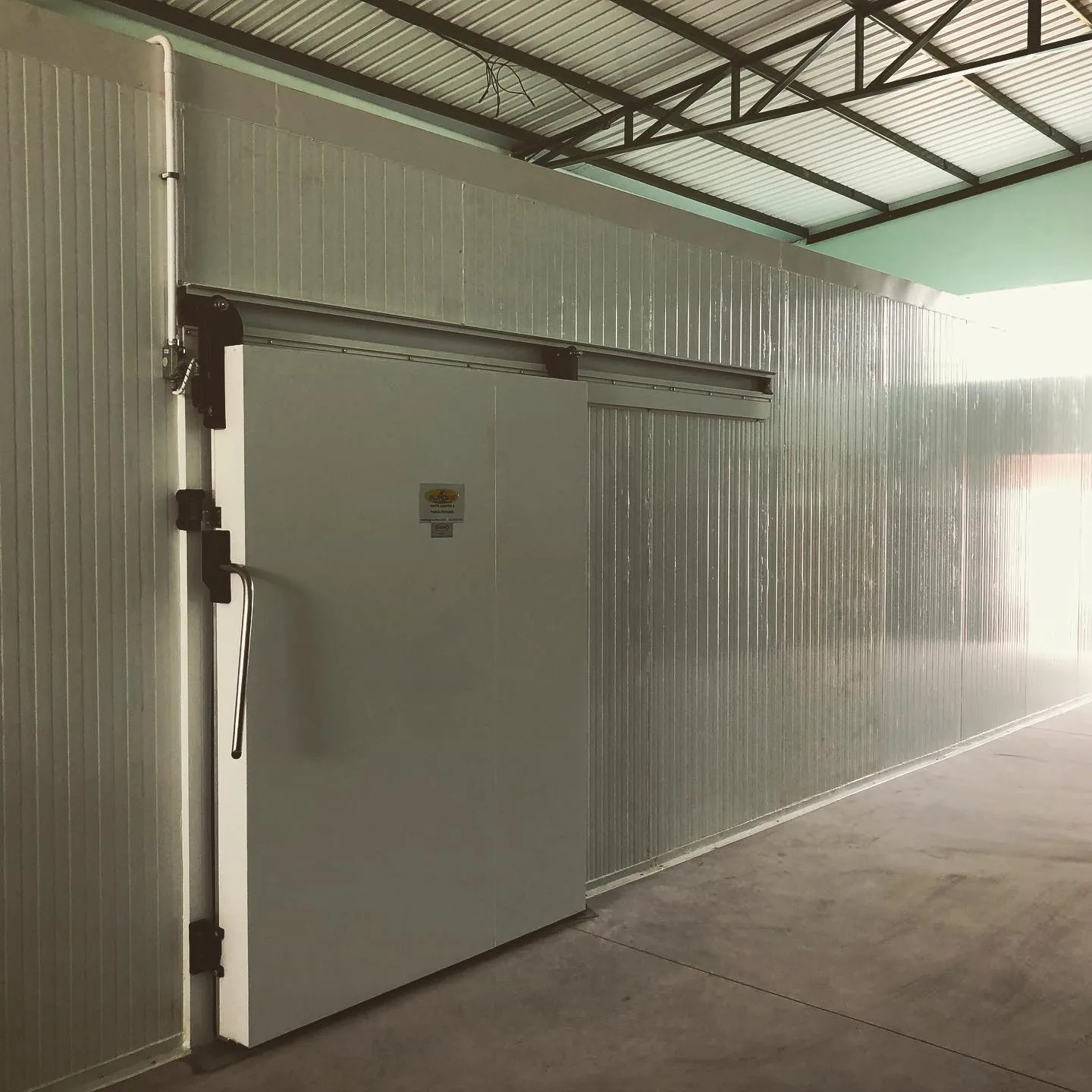 Porta de correr de câmara frigorífica de grande porte em galpão industrial