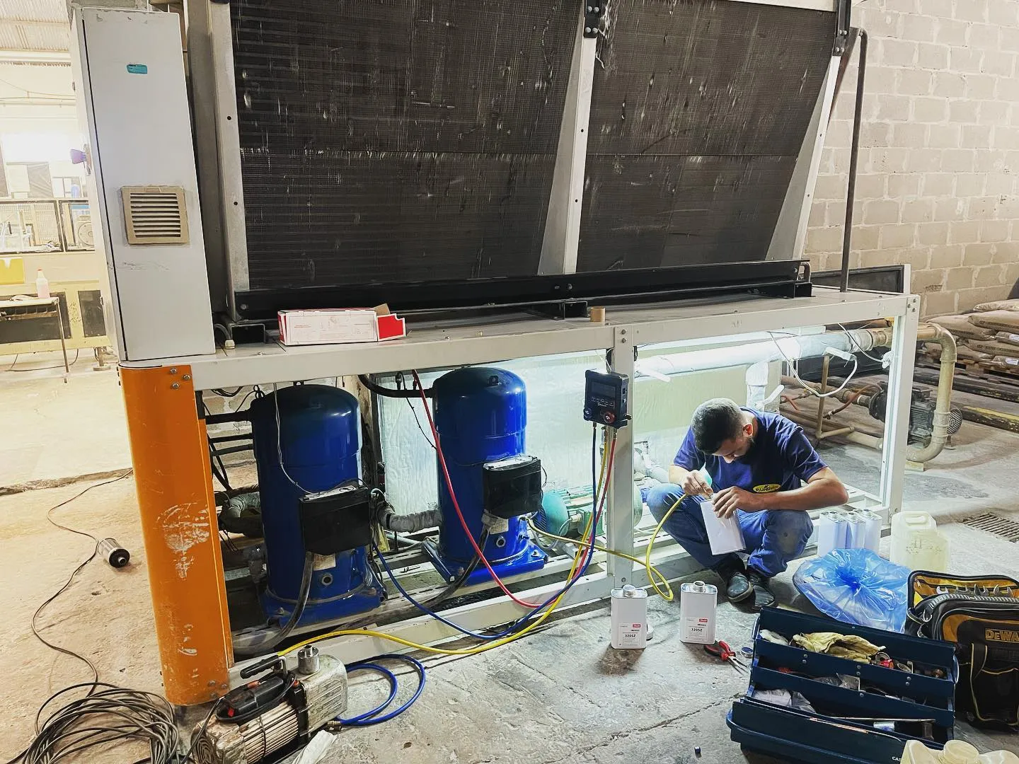 Técnico realizando manutenção em chiller industrial com compressores scroll