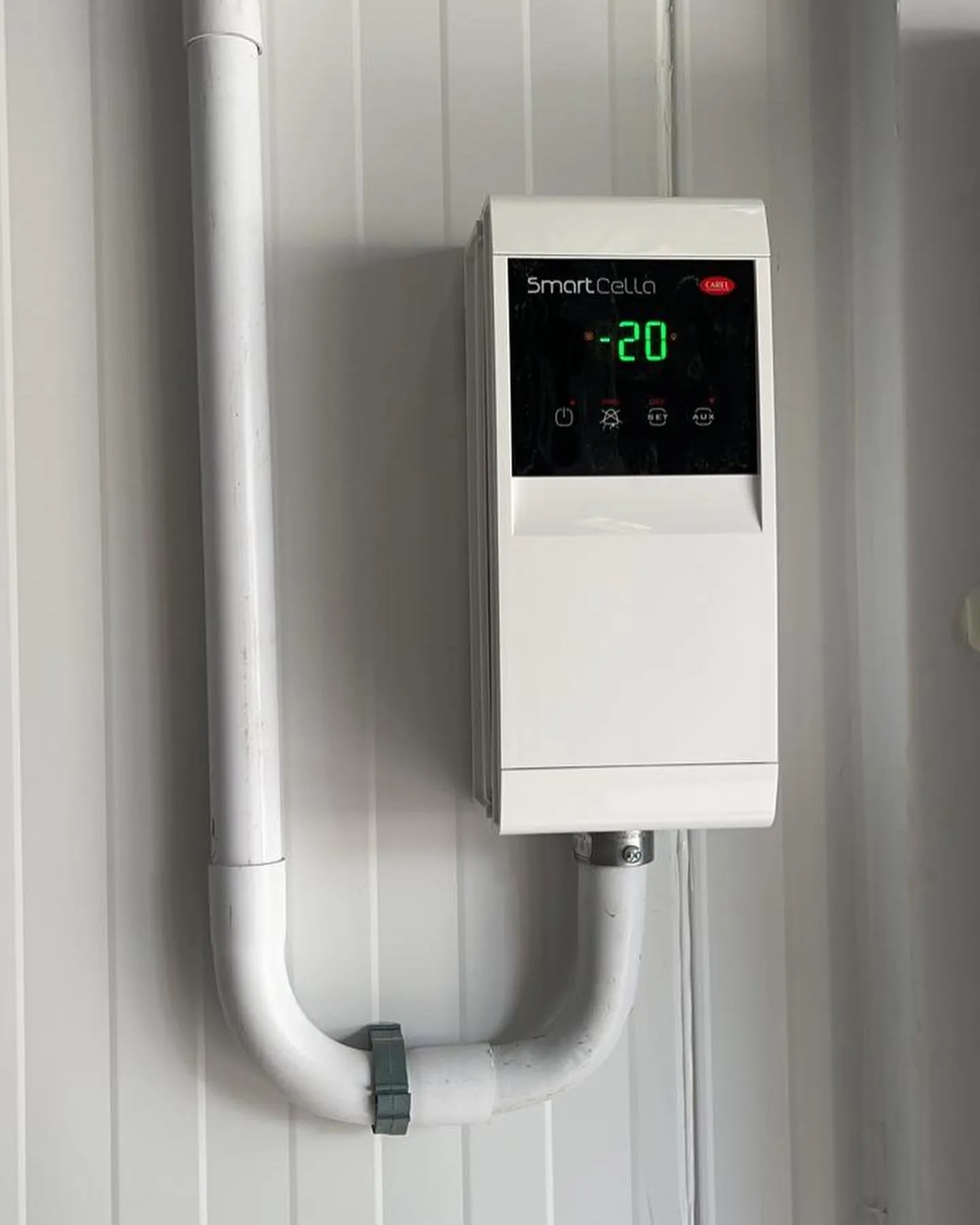 Controlador Carel SmartCella exibindo -20 °C em parede de câmara fria