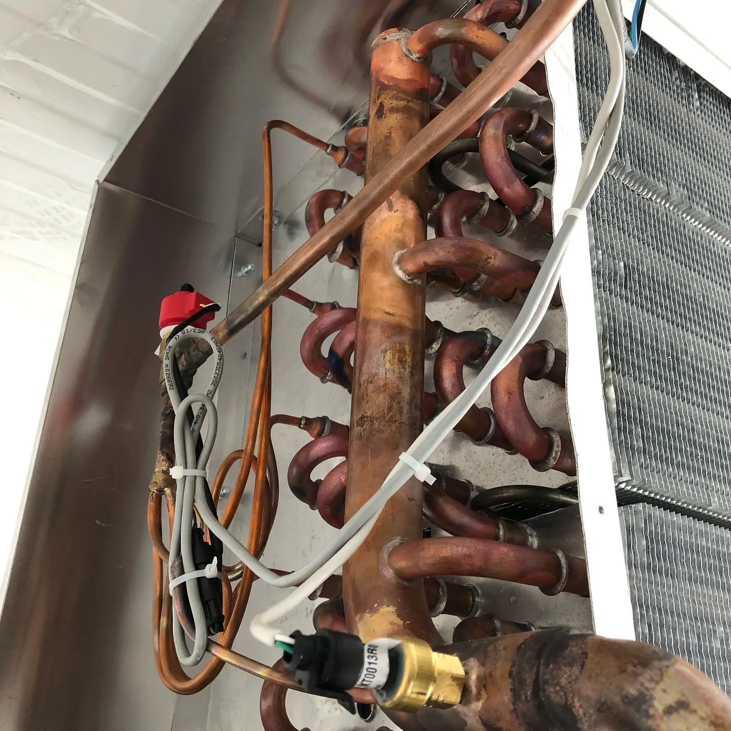 Detalhe de serpentina de cobre e válvula de expansão eletrônica em evaporador