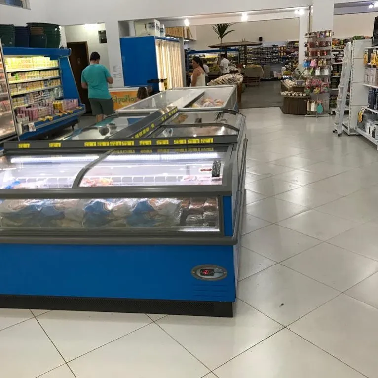 Ilhas de congelados azuis em supermercado com piso claro