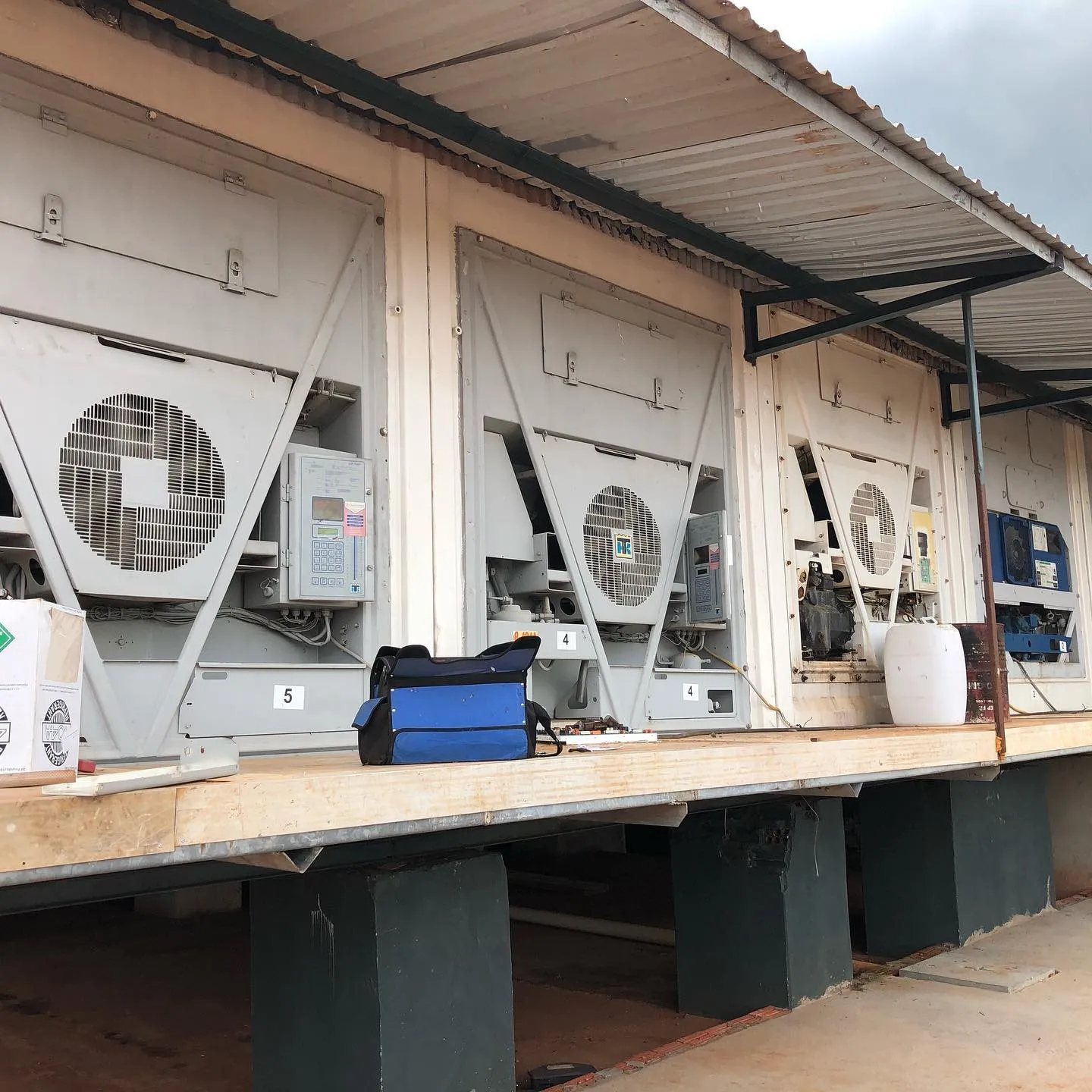 Fileira de contêineres frigoríficos com unidades de refrigeração em manutenção